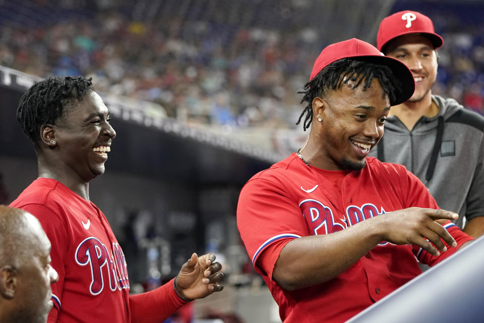 Philadelphia Phillies' Didi Gregorius, top left, and Jean Segura, front right, joke in the dugout during a baseball game against the Miami Marlins, Saturday, April 16, 2022, in Miami. (AP Photo/Lynne Sladky)