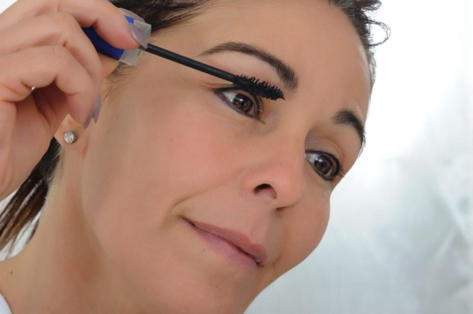 50-year-old woman put mascara in front of mirror