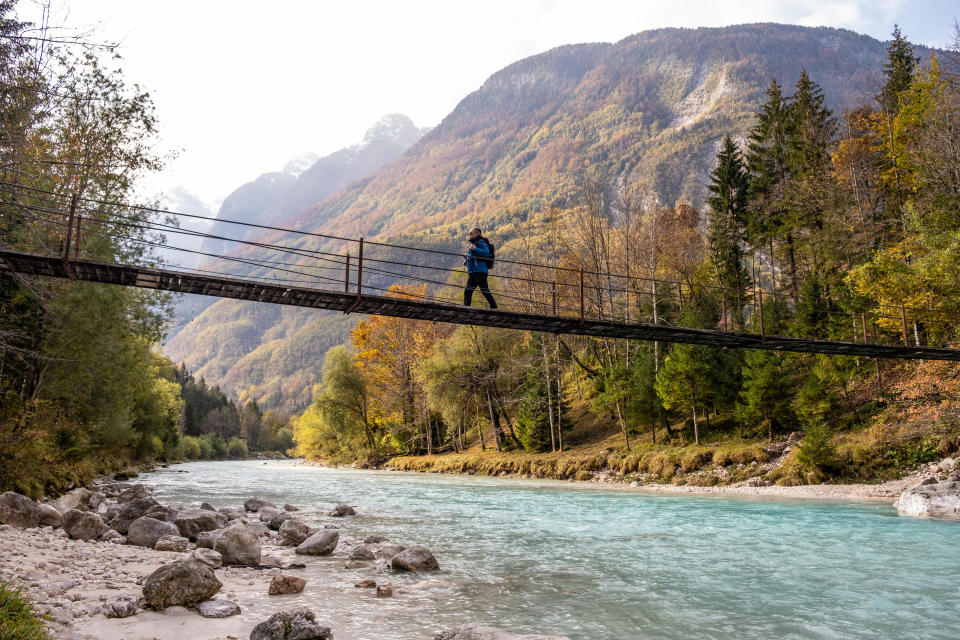 Senior Man walking on the Suspension bridge over Soča River in Julian Alps.