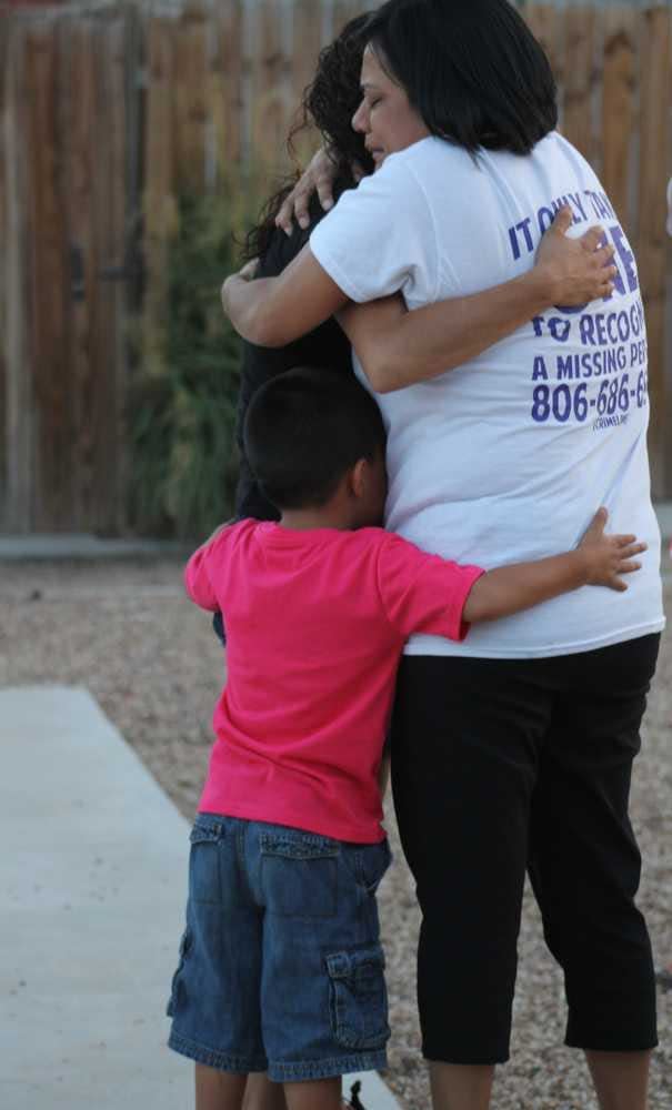 Melinda Campos hugs her daughter Savannah and grandson, Isaiah, on Thursday at the Courtyards at Monterey apartment complex during a vigil for her other daughter, Zoe, who was last seen Nov. 17.