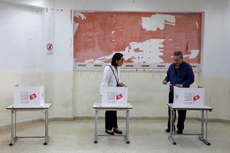 People prepare to cast their votes during a second round runoff of a presidential election in Tunis