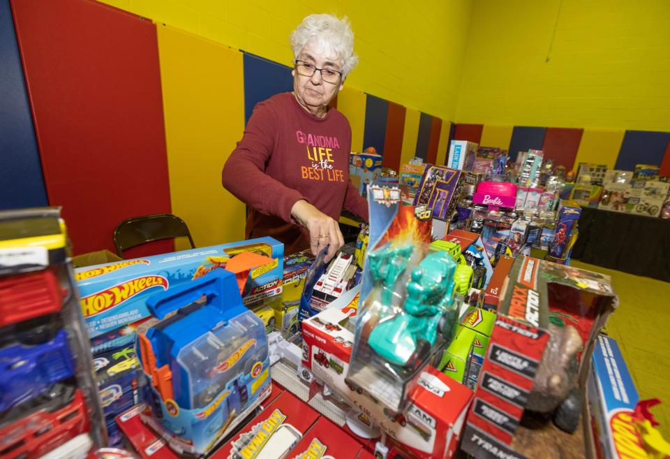 Cathy Harrison, a volunteer with the Alliance Salvation Army, sets out toys for the organization's annual Christmas distribution.