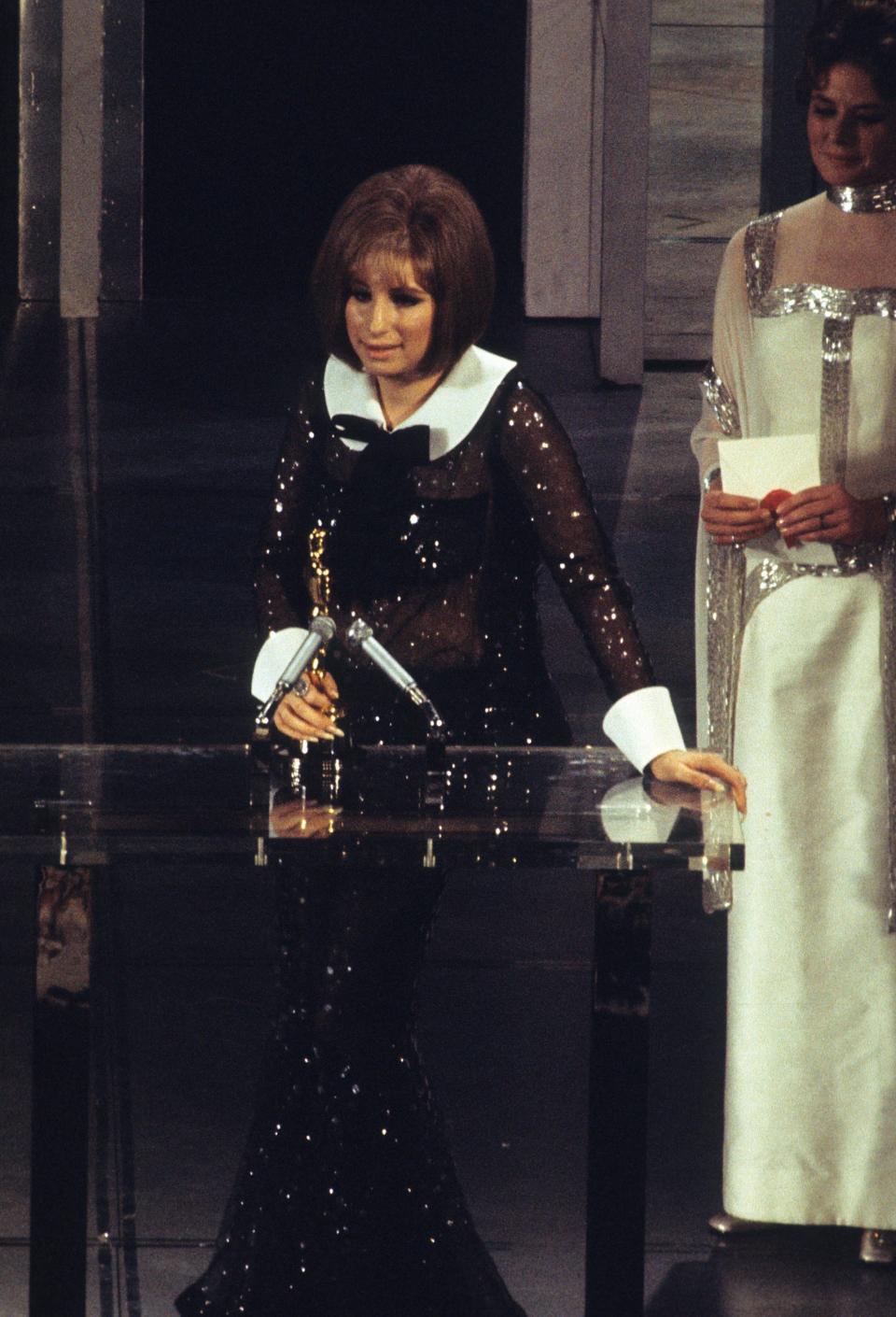 Barbra Streisand giving her acceptance speech with Ingrid Bergman behind her.