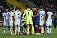 Players gather around Real Sociedad's Robin Le Normand who got kicked in the head during a challenge by Barcelona's Ilkay Gundogan during a Spanish La Liga soccer match between Barcelona and Real Sociedad at the Olimpic Lluis Companys stadium in Barcelona, Spain, Monday, May 13, 2024. (AP Photo/Joan Monfort)