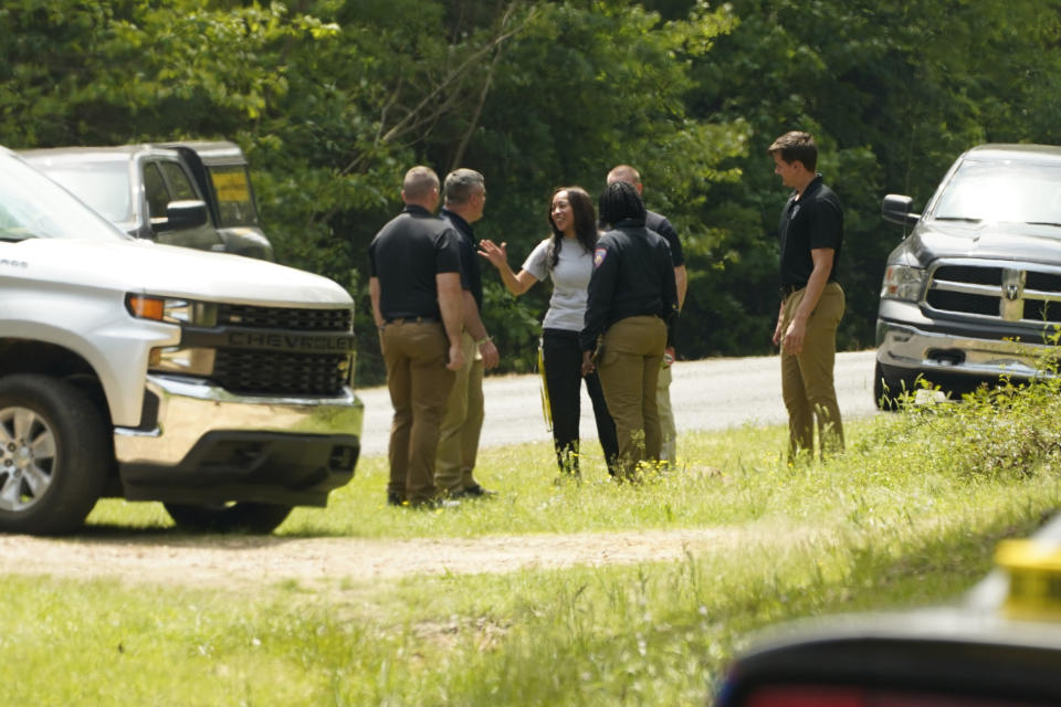 Investigators confer at the site of a burned out house where authorities believe a man who escaped from a Mississippi jail over the weekend with three others, and is suspected of killing a pastor, is believed to be dead after a shootout with authorities and barricaded himself inside a burning home near Conway, Mississippi, Wednesday morning, April 26, 2023. (AP Photo/Rogelio V. Solis)