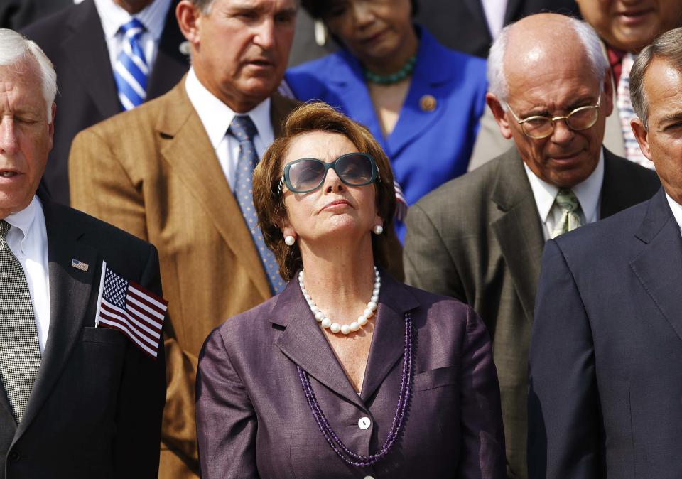 U.S. House Minority Leader Nancy Pelosi (D-CA) (C) observes a moment of silence during a remembrance of lives lost in the 9/11 attacks, on the steps of the U.S. Capitol in Washington, September 11, 2013. Bagpipes, bells and a reading of the names of the nearly 3,000 people killed when hijacked jetliners crashed into the World Trade Center, the Pentagon and a Pennsylvania field marked the 12th anniversary of the September 11 attacks in 2001. (REUTERS/Jonathan Ernst)
