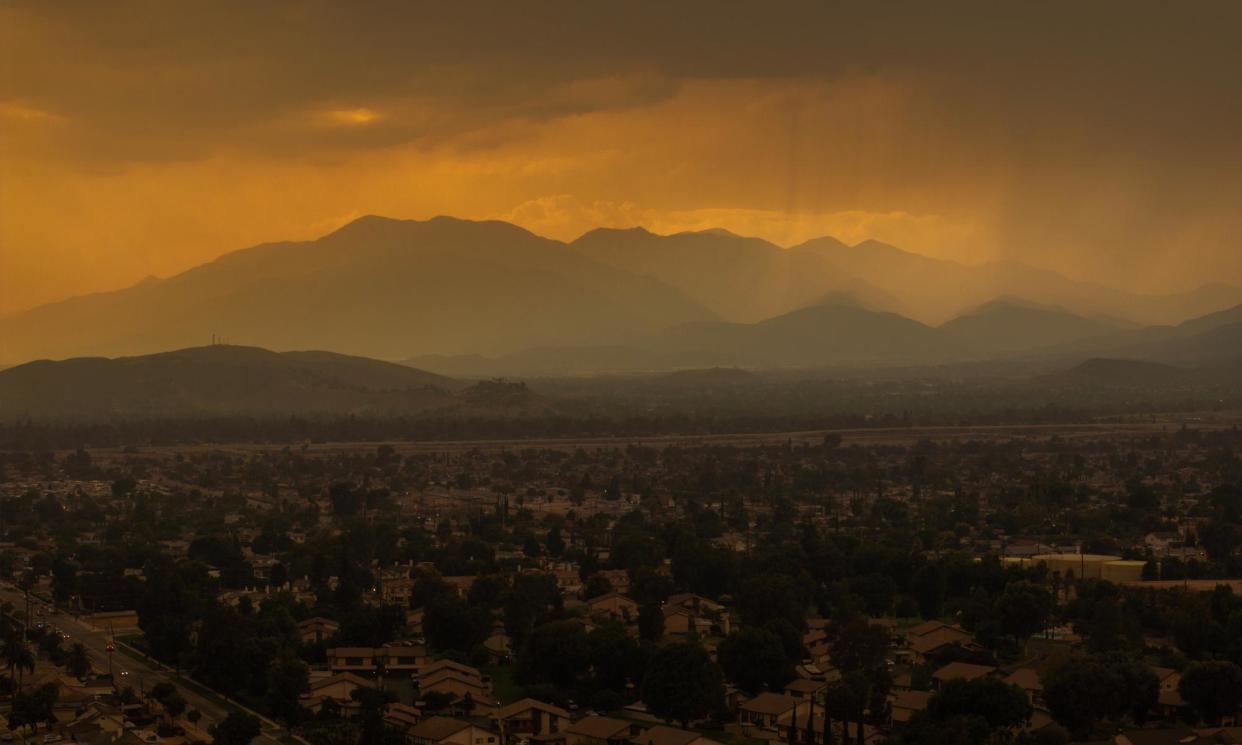 <span>A mix of rain and smoke from the nearby Line fire creates a heavy stew of air pollution over San Bernardino, California, on Sunday.</span><span>Photograph: David McNew/Getty Images</span>