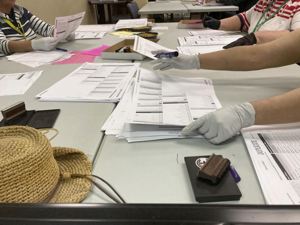 Election workers check ballots at elections offices in Clackamas County, Ore., the state's third most populous county south of Portland, Ore., Tuesday, May, 17, 2022. AP Photo/Gillian Flaccus)