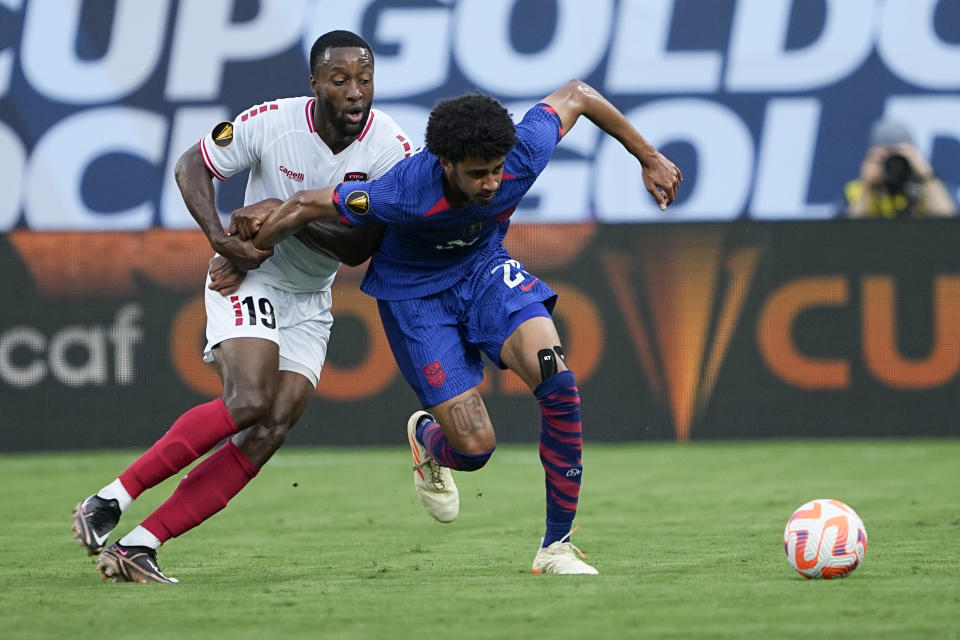 Trinidad and Tobago forward Malcolm Shaw and United States defender Jalen Neal vie for the ball during the first half of a CONCACAF Gold Cup soccer match on Sunday, July 2, 2023, in Charlotte, N.C. (AP Photo/Chris Carlson)
