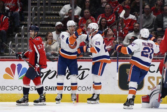 New York Islanders left wing Pierre Engvall (18) celebrates his goal with center Brock Nelson (29) and center Kyle Palmieri (21) during the second period of an NHL hockey game next to Washington Capitals defenseman Trevor van Riemsdyk (57), Wednesday, March 29, 2023, in Washington. (AP Photo/Nick Wass)