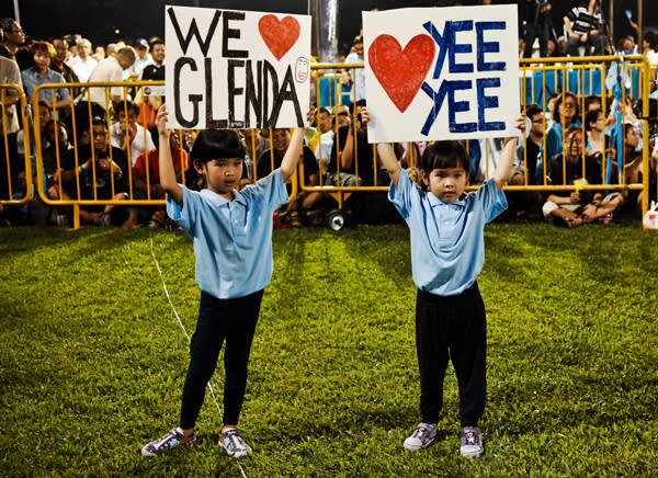Two girls, who are nieces of East Coast GRC candidate Glenda Han, hold up signs in support of their aunt as she makes her speech. (Yahoo! photo/ Terence Lee)