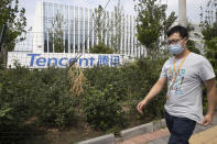 A man walks past the Tencent headquarters in Beijing, China on Friday, Aug. 7, 2020. President Donald Trump on Thursday ordered a sweeping but unspecified ban on dealings with the Chinese owners of consumer apps TikTok and WeChat, although it remains unclear if he has the legal authority to actually ban the apps from the U.S. WeChat is owned by Chinese company Tencent. (AP Photo/Ng Han Guan)