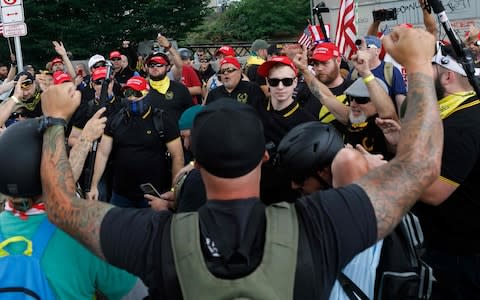 Hundreds of members of far-right groups face some Antifa protestors during "The End Domestic Terrorism" rally at Tom McCall Waterfront Park in Portland - Credit: AFP