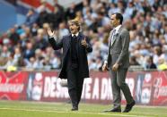 Wigan Athletic manager Roberto Martinez (right) and Manchester City manager Roberto Mancini on the touchline
