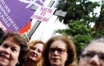 <p>A crosss with a sign reading “Enough of Femicide” is pictured next to women during the rally on the World Day for the Elimination of Violence against Women in Sao Paulo, Brazil, Nov. 25, 2017. (Photo: Nacho Doce/Reuters) </p>