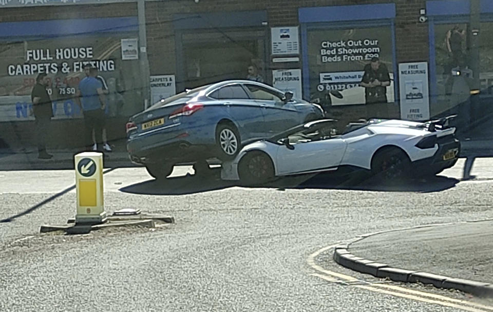 A luxury Lamborghini worth hundreds of thousands of pounds has been involved in a spectacular collision that left another car resting on its bonnet.  (SWNS)