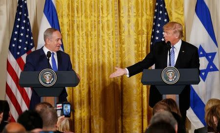 U.S. President Donald Trump (R) reaches to greet Israeli Prime Minister Benjamin Netanyahu after a joint news conference at the White House in Washington, U.S., February 15, 2017. REUTERS/Kevin Lamarque