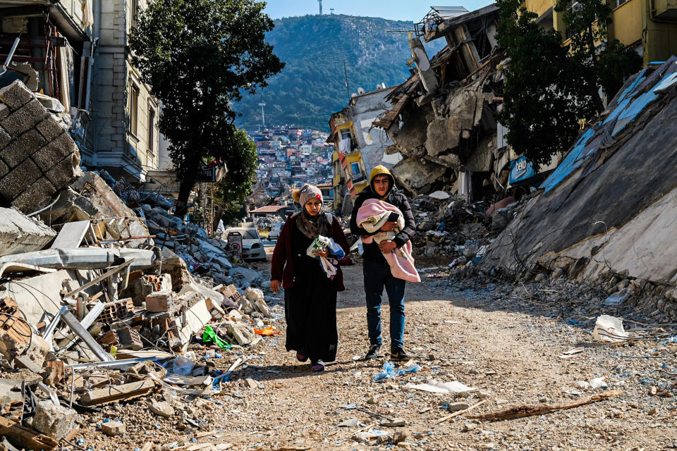 dpatopbilder - 12.02.2023, Türkei, Hatay: Eine Frau und ein junger Mann gehen durch die Trümmer des verheerenden Erdbebens vom 06.02.2023. Eine Woche nach dem Erdbeben im türkisch-syrischen Grenzgebiet ist die Zahl der Toten auf mehr als 30 000 gestiegen. Foto: Murat Kocabas/SOPA Images via ZUMA Press Wire/dpa +++ dpa-Bildfunk +++