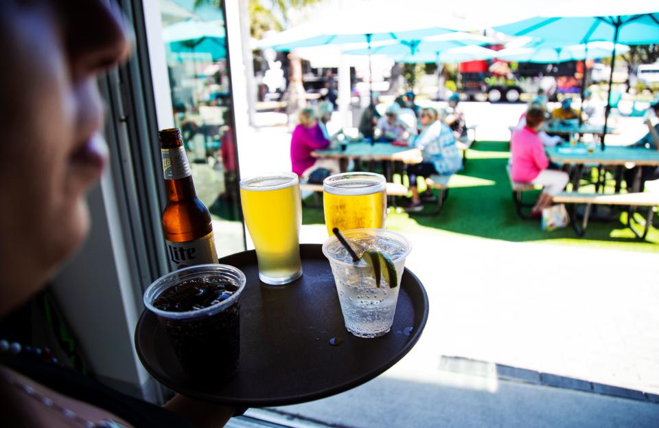 Angelina Misseri, a server at the Rooftop at Riverside delivers drinks to patrons at the recently opened restaurant, bar along Old U.S. 41 in Bonita Springs. Photographed on March 19, 2024. It houses several food trucks as well.