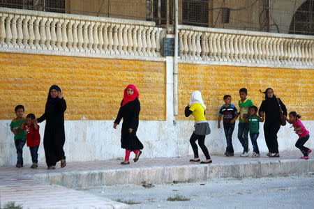 Civilians react as they rush away after hearing the sound of a Syrian fighter jet hovering over Idlib city, Syria July 18, 2015. REUTERS/Ammar Abdullah