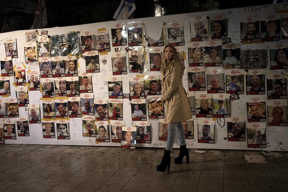 A woman visits a display of posters of people taken hostage by Hamas on Oct. 7, 2023, during a weekly rally calling for their release, in Tel Aviv, Israel, Saturday, Feb. 3, 2024. (AP Photo/Maya Alleruzzo)