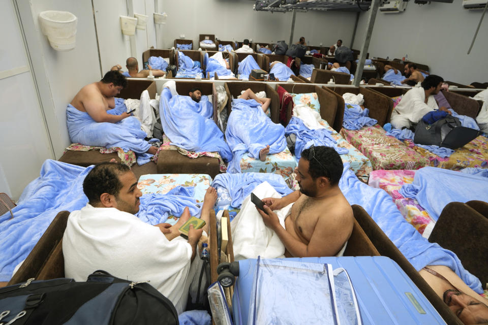 Muslim pilgrims rest and read the Quran, the Muslims holy book, at the Mina tent camp during the Hajj, in Mecca, Saudi Arabia, during the annual hajj pilgrimage, Monday, June 26, 2023. Muslim pilgrims are converging on Saudi Arabia's holy city of Mecca for the largest hajj since the coronavirus pandemic severely curtailed access to one of Islam's five pillars. (AP Photo/Amr Nabil)