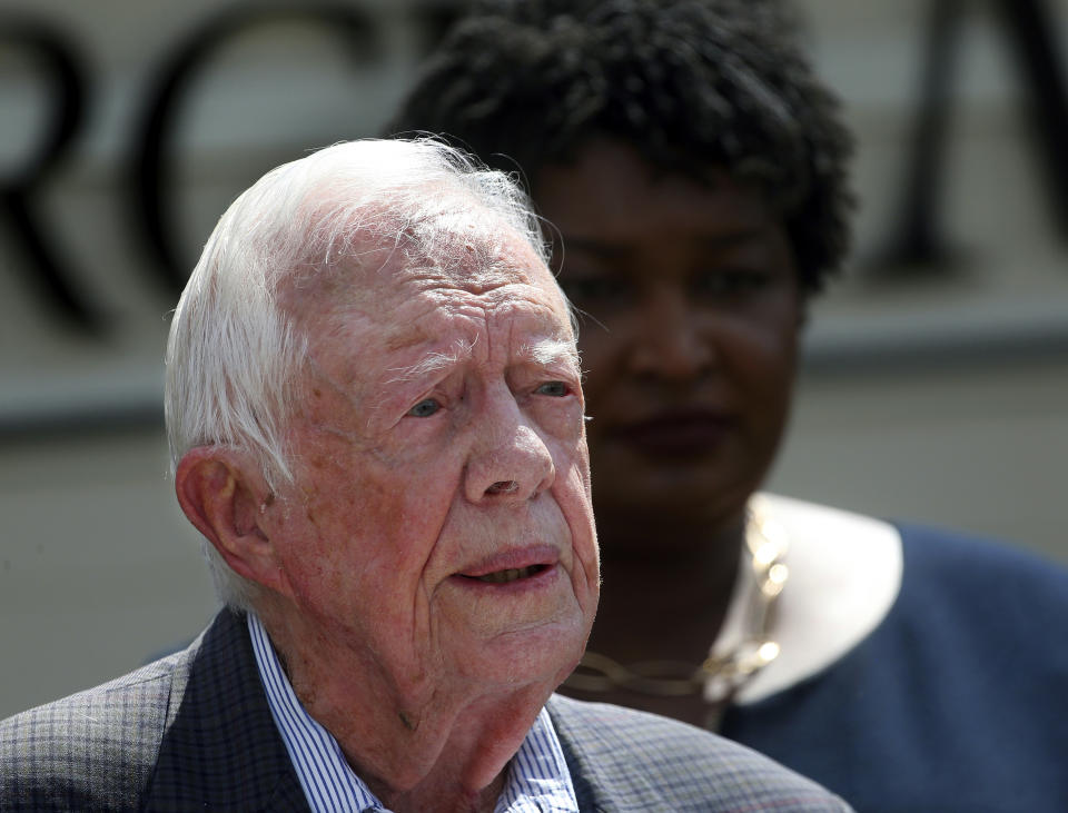 FILE- In this Sept. 18, 2018 file photo, former President Jimmy Carter speaks as Democratic gubernatorial candidate Stacey Abrams listens during a news conference to announce her rural health care plan, in Plains, Ga. Carter is now the longest-living president in American history. The 39th president on Friday, March 15, 2019, reached the age of 94 years, 172 days - one day beyond the lifespan of George H.W. Bush, who died in November. (AP Photo/John Bazemore, File)