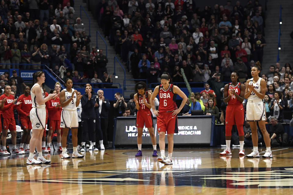 Connecticut players and US National players stand for a 24 second shot-clock violation to honor Kobe Bryant during an exhibition basketball game in the first half of a basketball game, Monday, Jan. 27, 2020, in Hartford, Conn. (AP Photo/Jessica Hill)