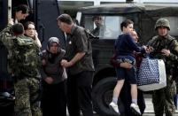 People are evacuated with an armored vehicle near a police checkpoint in Kumanovo, Macedonia, May 9, 2015. REUTERS/Ognen Teofilovski