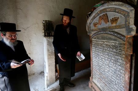 Two rabbis pray at the tomb of a leading Hasidic rabbi in the cemetery of the village of Mad in Hungary, July 21, 2016. Before World War Two, Jewish families had played an important role in producing and trading Hungary's famous Tokaji wines. Picture taken July 21, 2016. REUTERS/Laszlo Balogh