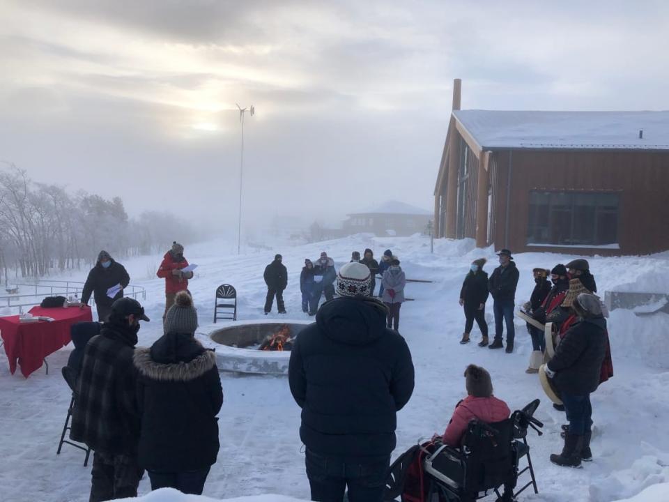 Approximately 30 people gathered around the fire at Saturday's vigil in Carcross, Yukon, to pray, play sombre drum music and light candles.  (Mike Rudyk/CBC - image credit)