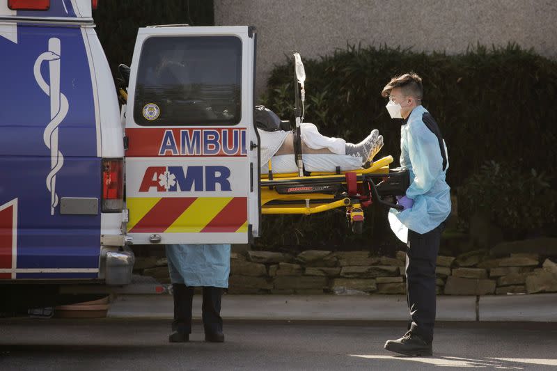 Medics load a person into an ambulance outside of the Life Care Center of Kirkland