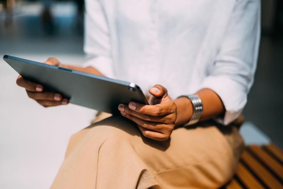 A close up of a person holding up a tablet.