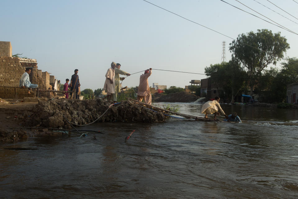 Residents rush to rescue a man from drowning on an embankment between Hayat Khaskheli village and the city of Jhuddo, Sept. 9.<span class="copyright">Hassaan Gondal for TIME</span>