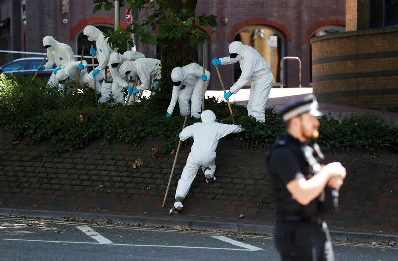 Forensic officers search near the scene of reported multiple stabbings in Reading