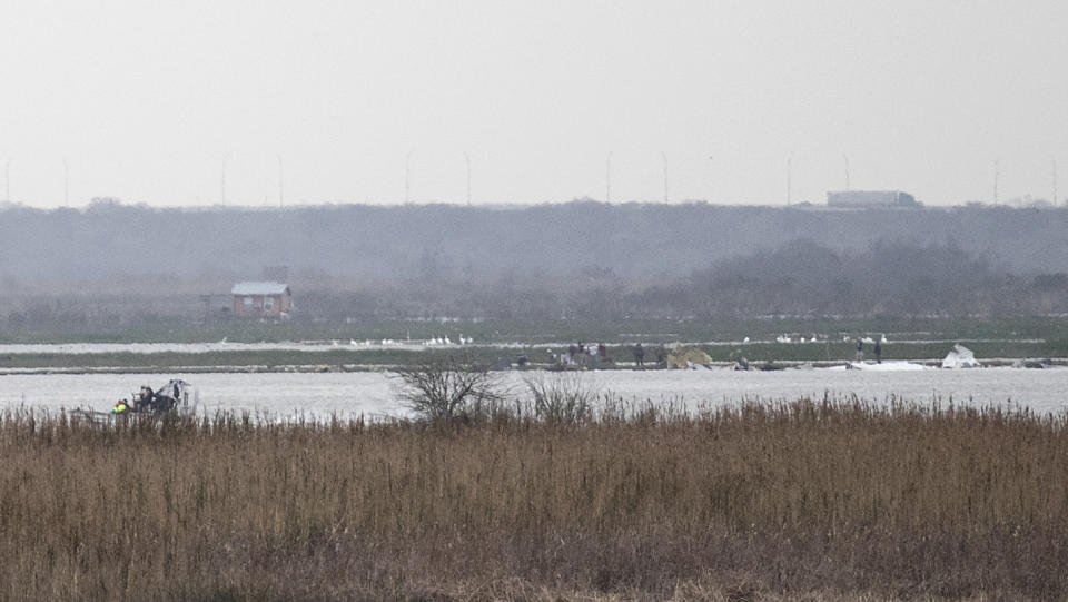 Emergency personnel work at the scene of a plane crash site in Trinity Bay in Anahuac, Texas on Saturday, Feb. 23, 2019. The Federal Aviation Administration said a Boeing 767 cargo plane went down approximately 30 miles southeast of Houston's George Bush Intercontinental Airport. (Brett Coomer/Houston Chronicle via AP)