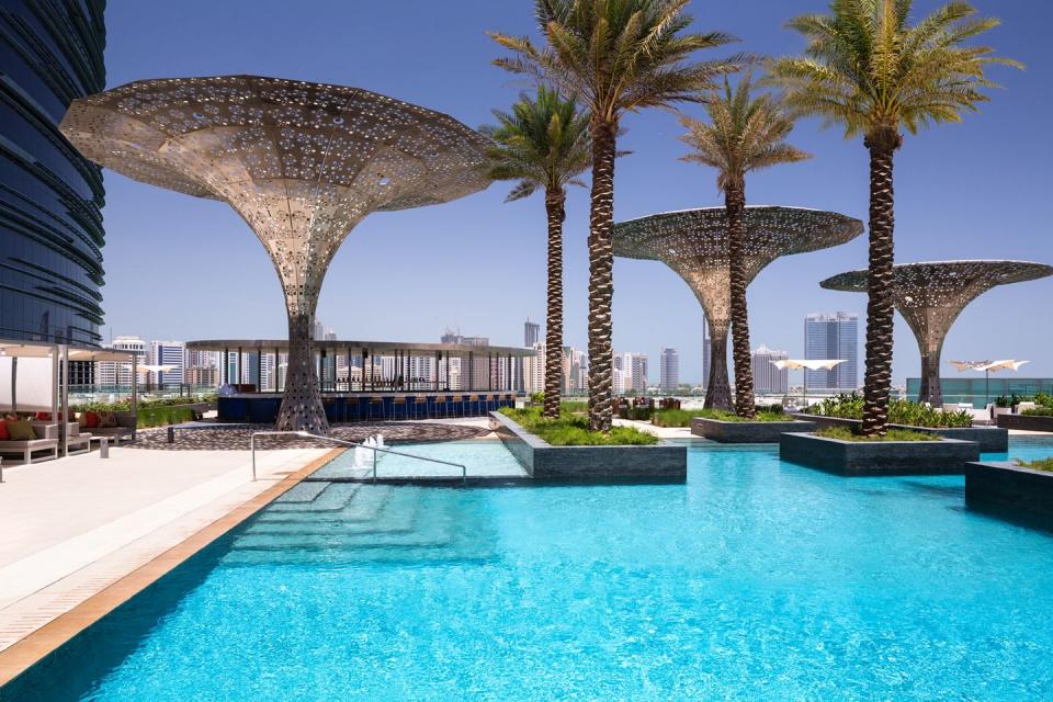 a pool with palm trees and a structure in the background