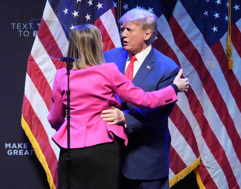 Iowa Gov. Kim Reynolds embraces former President Donald Trump at a campaign event in Davenport, Monday, March 13, 2023. 