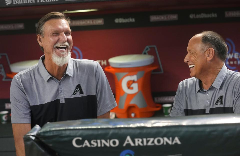 Former Arizona Diamondbacks players Randy Johnson and Luis Gonzalez share a laugh as the team celebrates its 25th anniversary season before their game against the San Diego Padres at Chase Field in Phoenix on Aug. 12, 2023.