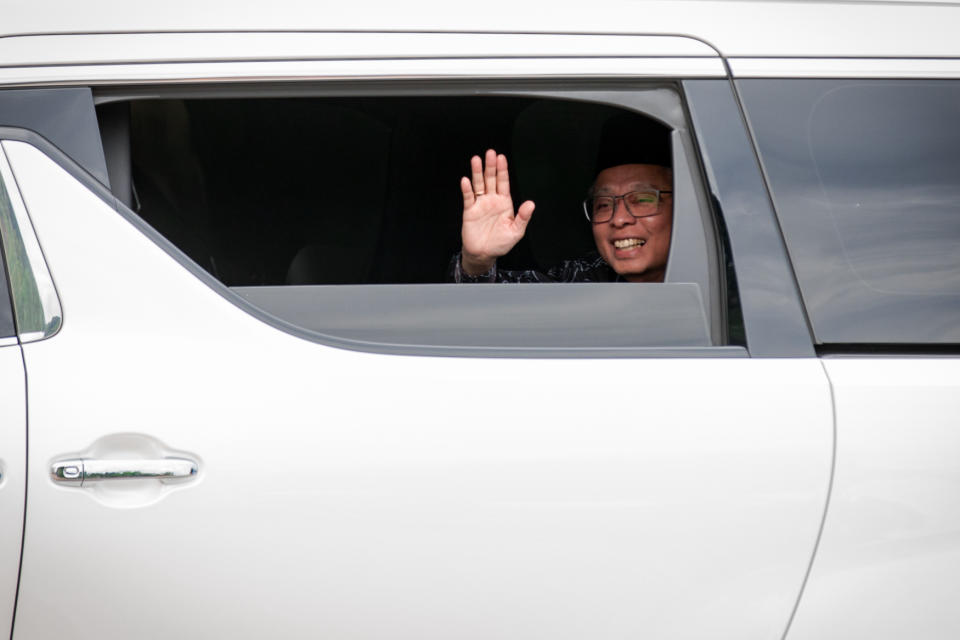 Ninth Prime Minister of Malaysia, Ismail Sabri, waving to the crowd in a limousine .