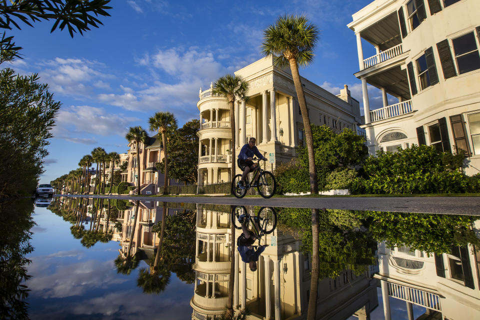 A bicyclist makes his way down East Battery as a king tide rolls into the historic Battery causing flooding in Charleston, S.C. Sunday, Nov. 15, 2020. Charleston has remained relatively unscathed this hurricane season. That means more time to mull a $1.75 billion proposal by the Army Corps of Engineers that features a sea wall along the city's peninsula to protect it from deadly storm surge during hurricanes. (AP Photo/Mic Smith)