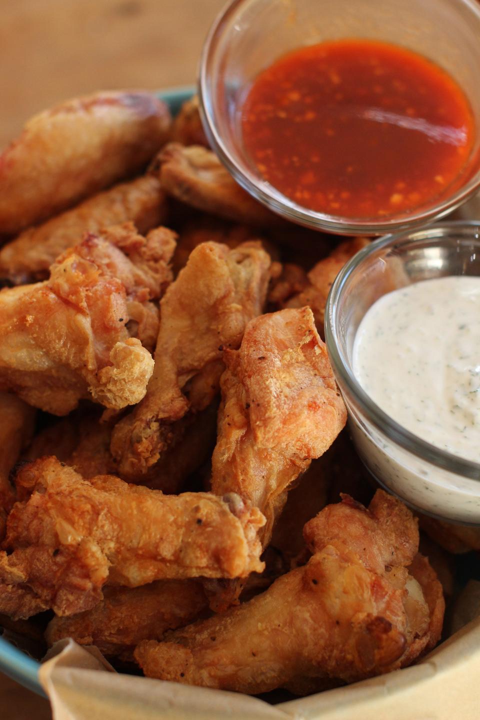 This Nov. 16, 2015, photo shows hands-off party wings with cilantro sour cream dip and honey sriracha in Concord, N.H.