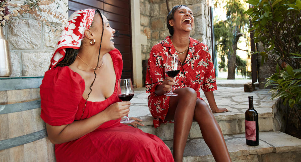 two female friends laughing with wine