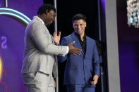 Mississippi quarterback Matt Corral, right, shakes hands with Mississippi State offensive lineman Charles Cross during the first round of the NFL football draft Thursday, April 28, 2022, in Las Vegas. (AP Photo/John Locher)