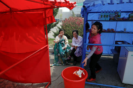 FILE PHOTO: Women wearing traditional clothes enjoy ice-cream in central Pyongyang, North Korea April 16, 2017. REUTERS/Damir Sagolj/File Photo