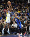 Golden State Warriors forward Andrew Wiggins, left, shoots over Orlando Magic guard Markelle Fultz (20) during the first half of an NBA basketball game Wednesday, March 27, 2024, in Orlando, Fla. (AP Photo/John Raoux)