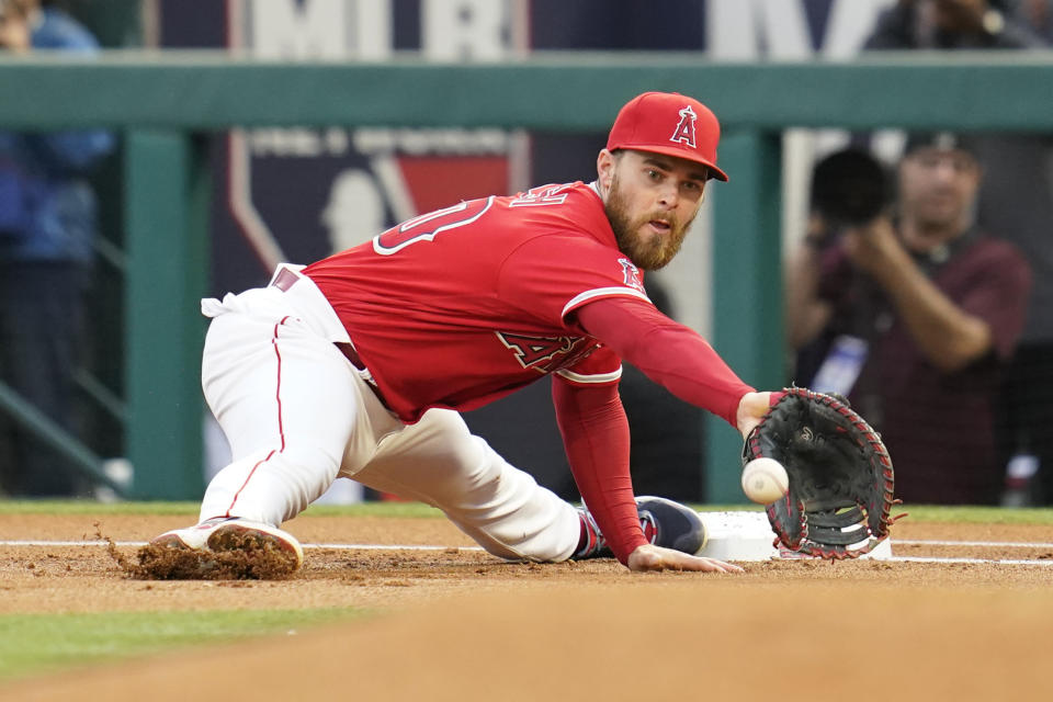 Los Angeles Angels first baseman Jared Walsh (20) catches a throw to first to out Toronto Blue Jays' Santiago Espinal (5) during the first inning of a baseball game in Anaheim, Calif., Saturday, May 28, 2022. (AP Photo/Ashley Landis)