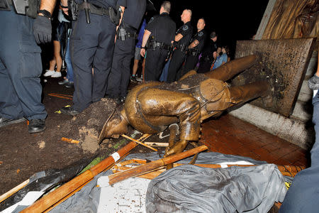 FILE PHOTO: University of North Carolina police surround the toppled statue of a Confederate soldier nicknamed Silent Sam on the school's campus after a demonstration for its removal in Chapel Hill, North Carolina, U.S. August 20, 2018. REUTERS/Jonathan Drake/File Photo