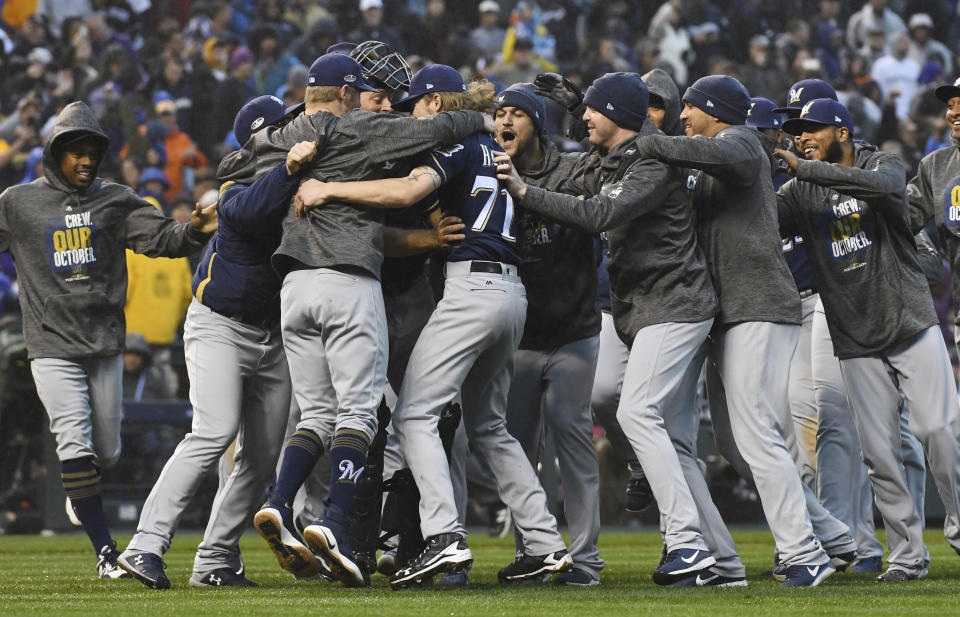 Milwaukee Brewers celebrate after the final out by the Colorado Rockies in the ninth inning of Game 3 of a baseball National League Division Series Sunday, Oct. 7, 2018, in Denver. The Brewers won 6-0 to sweep the series in three games and move on to the National League Championship Series. (AP Photo/John Leyba)