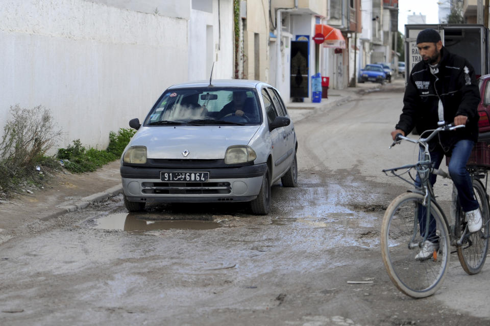 A man drives a car in a damaged street of La Marsa, outside Tunis, Wednesday, Dec. 14, 2022. To outsiders, Tunisia’s legislative elections Saturday, Dec. 17, 2022 look questionable: Many opposition parties are boycotting. A new electoral law makes it harder for women to compete. Foreign media aren’t allowed to talk to candidates. But many voters believe that their country’s decade-old democratic revolution has failed, and welcome their increasingly autocratic president’s political reforms. (AP Photo/Hassene Dridi)